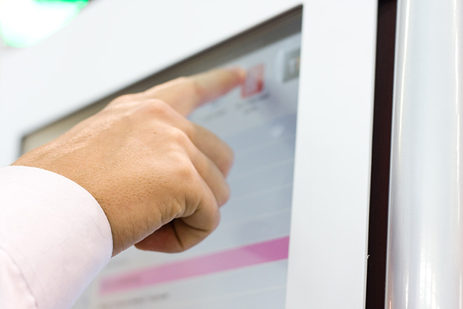 IK10 Monitor - Ticket vending machines a finger pointing at a screen