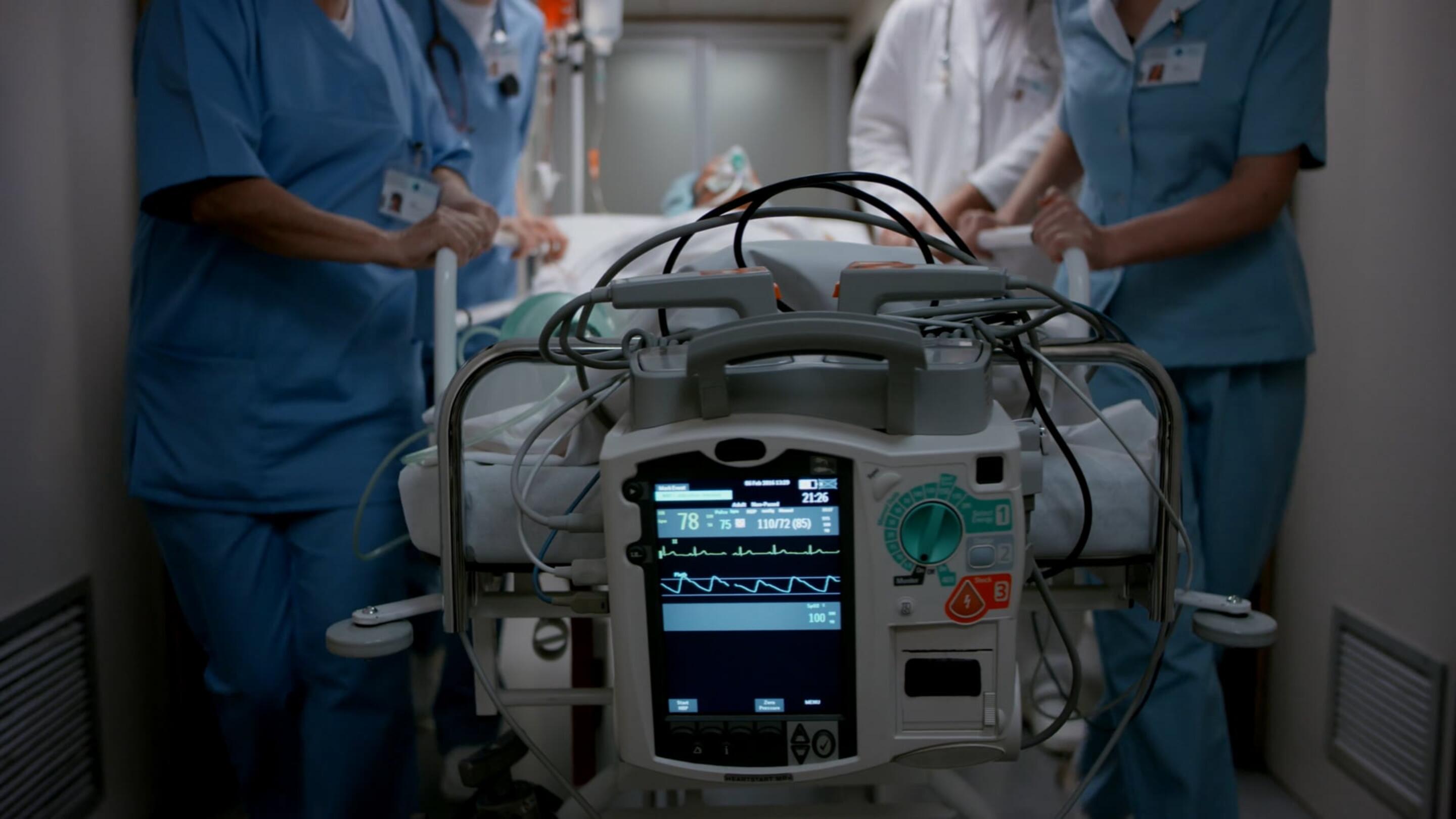 Medisch - Robuuste medische technologie medische mensen in scrubs die een medisch hulpmiddel duwen