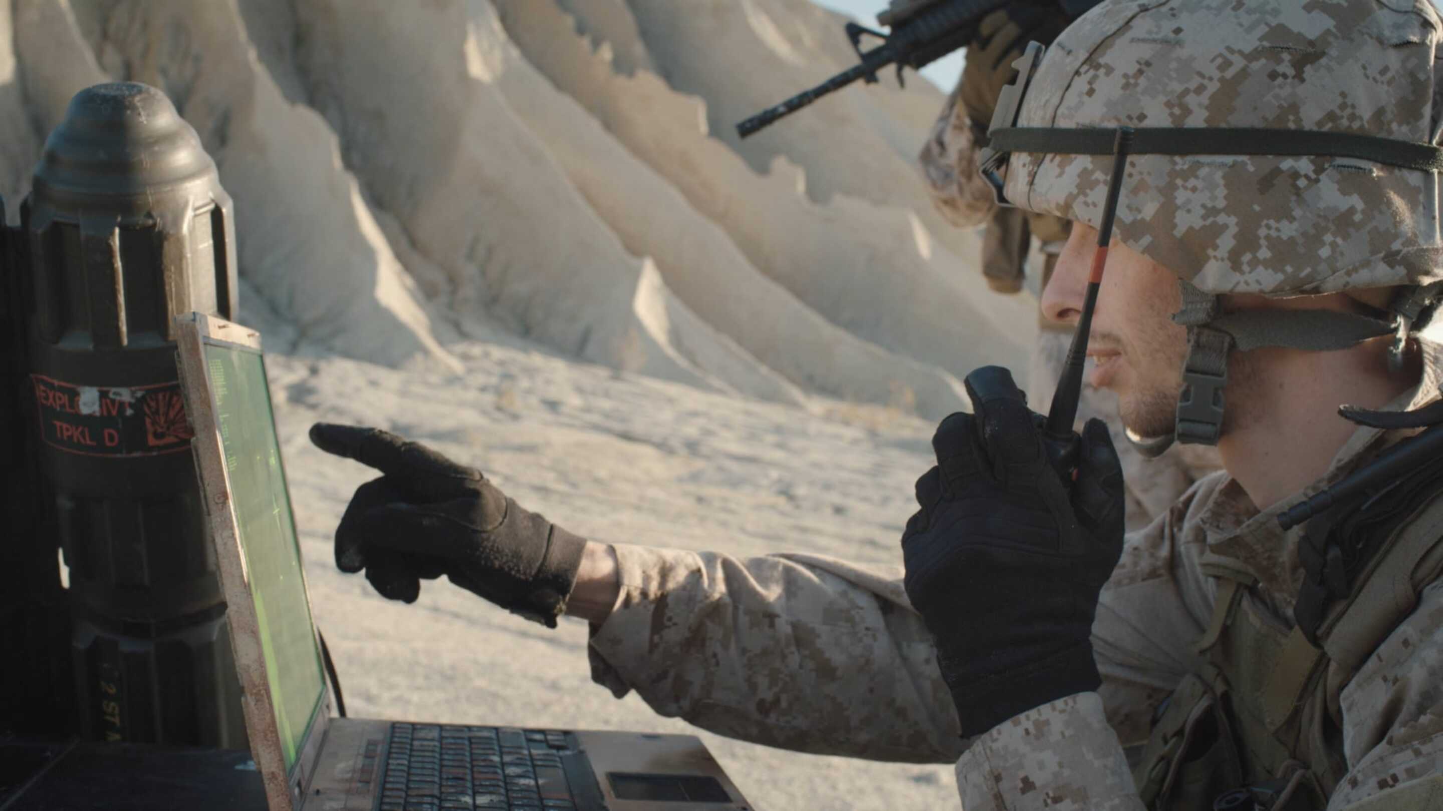 Tempest - Pantalla táctil militar: un hombre con uniforme militar usando una computadora portátil