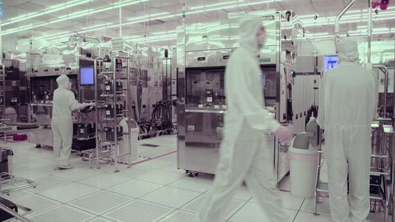 Priemyselný monitor - montáž čistých priestorov muž v bielom obleku kráčajúci v továrni